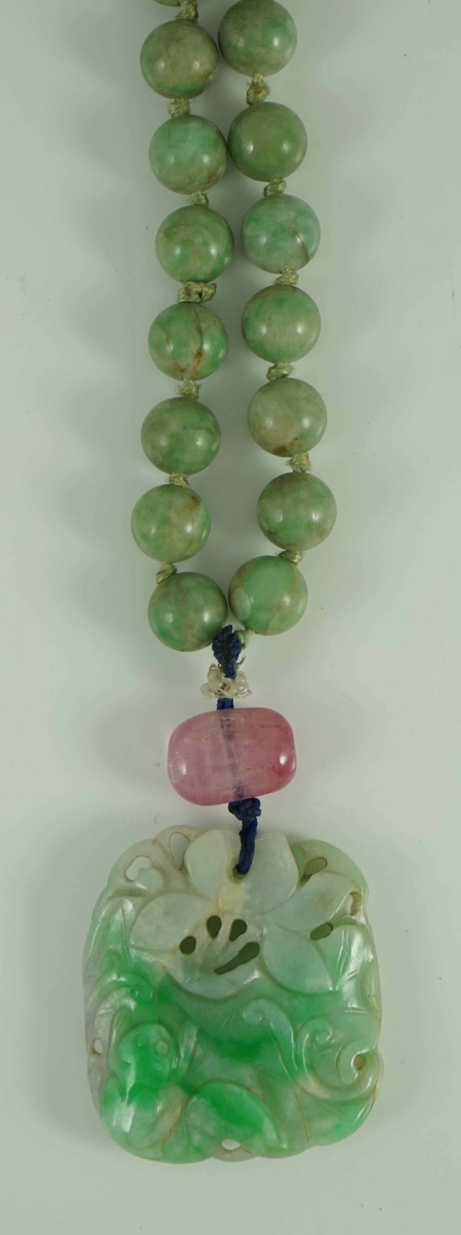 A Chinese jadeite pendant and jadeite beads, 19th century, Pendant 3.9 cm, total drop 68 cm